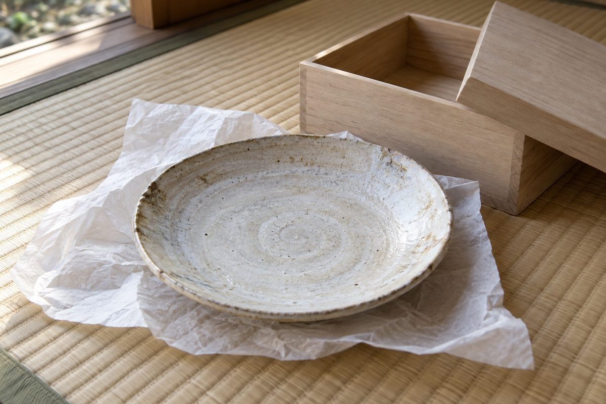 桐箱から出した古い皿と和紙、畳の上