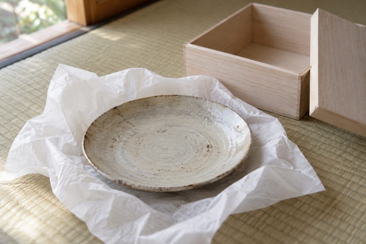 桐箱から出した古い皿と和紙、畳の上