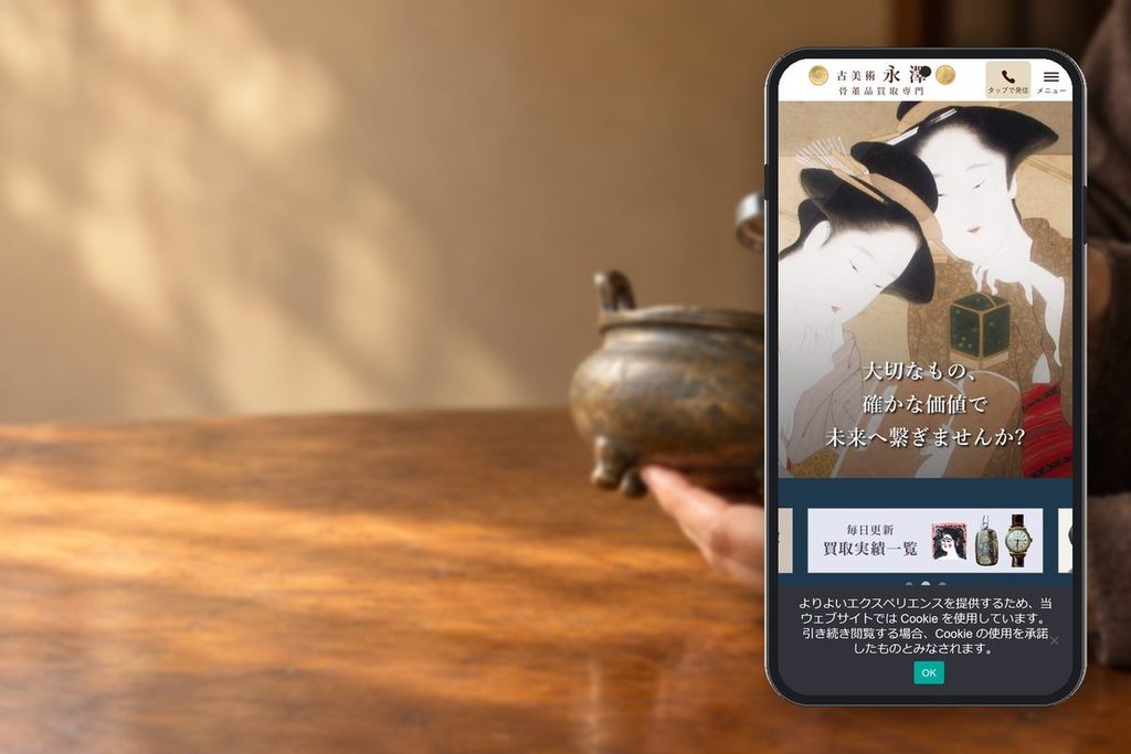 古美術永澤の公式サイトの画面をスマホに表示した写真